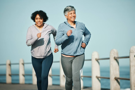 Two elderly women outside running