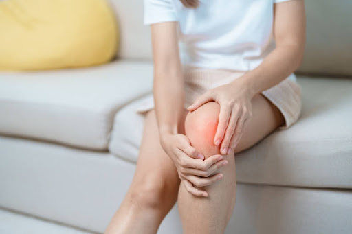 An elderly person holding their knee due to osteoarthritis pain